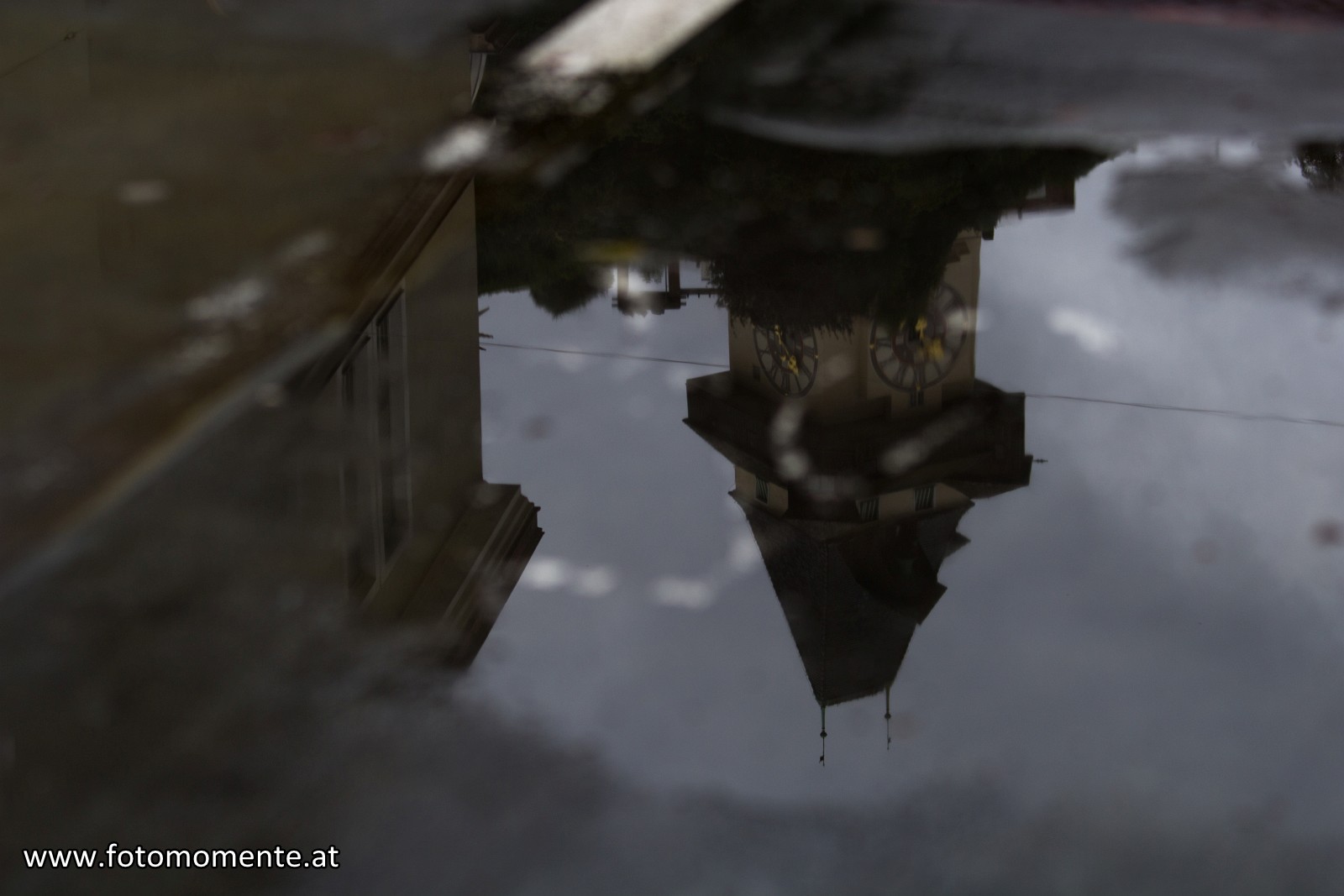 Uhrturmspiegelung in Regenpfütze